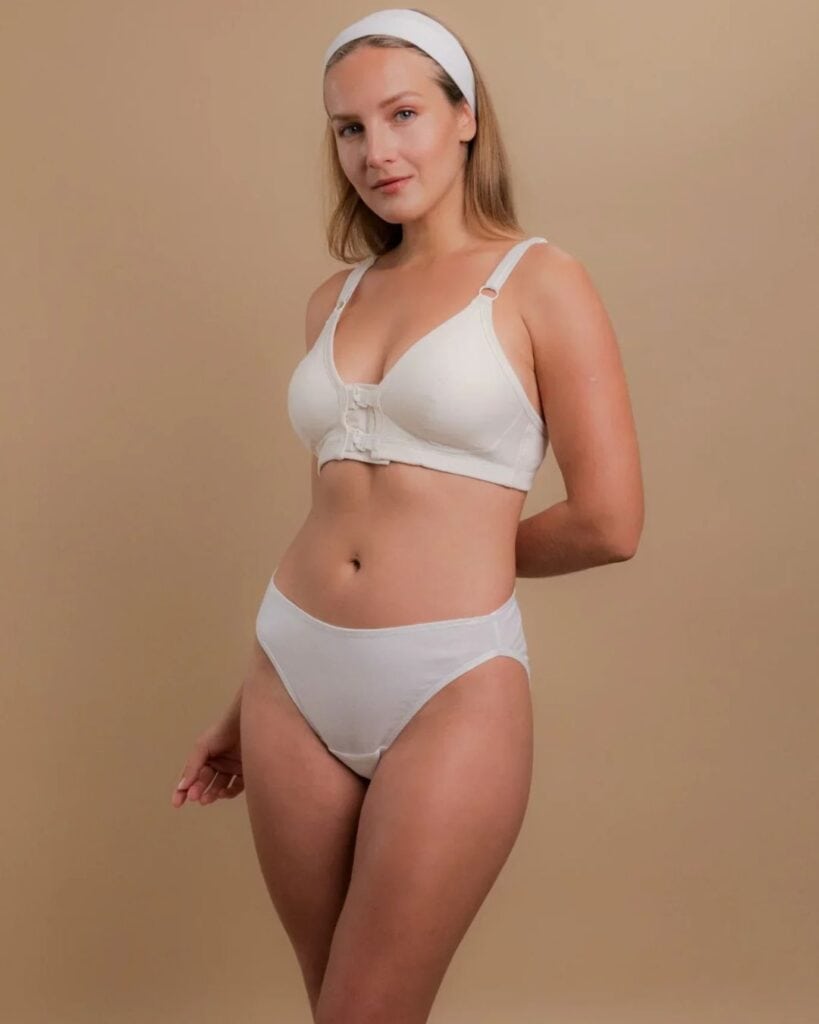 Model wearing white Cottonique organic cotton underwear with a matching front-closure cotton bra.