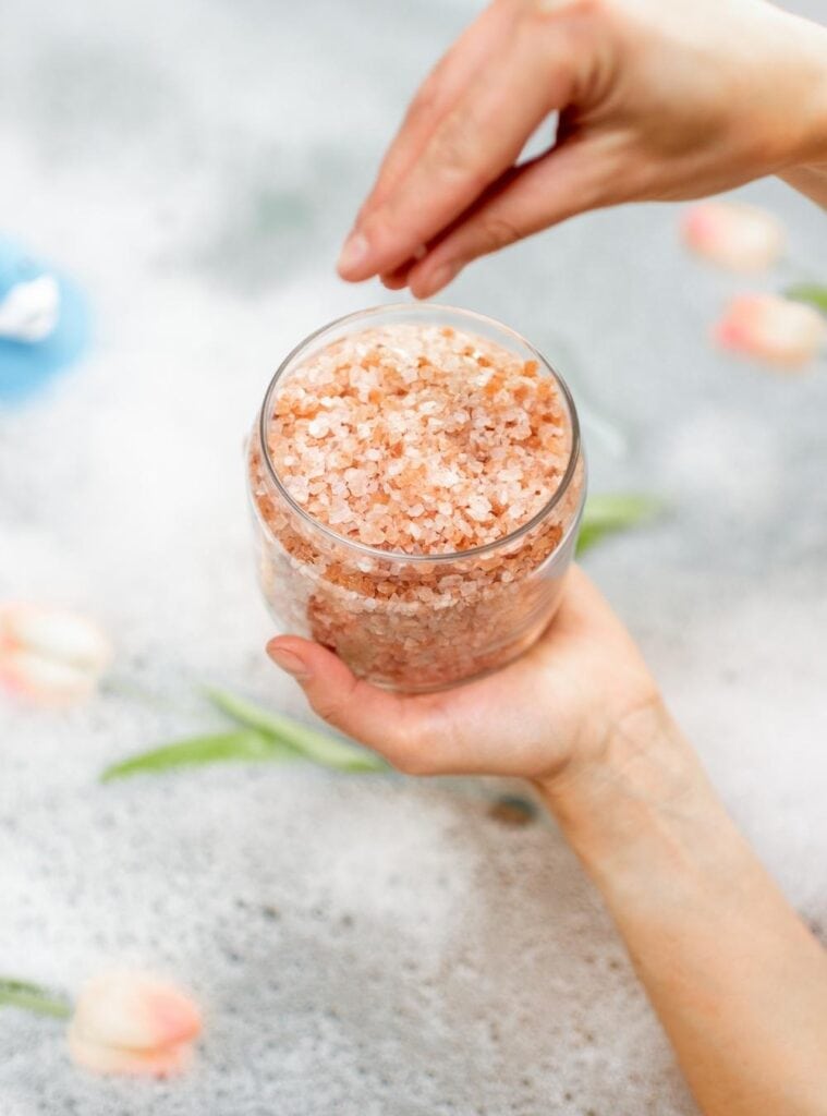Glass jar of eco-friendly homemade bath salts with dried lavender and a compostable label, perfect for a low-waste Christmas gift.