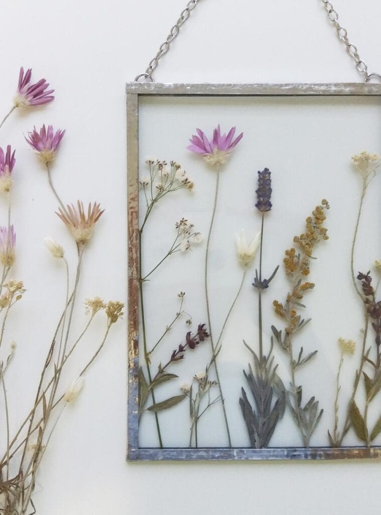 Framed pressed flowers in a minimal wooden frame as a handcrafted, eco-conscious holiday gift for flower lovers.