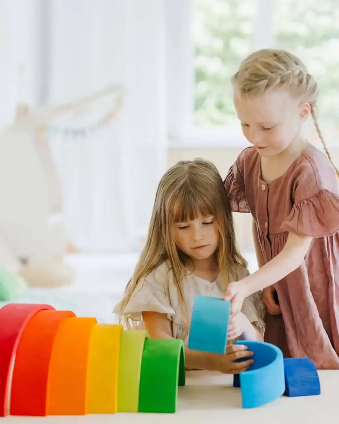 Sustainable wooden rainbow stacking toy for open-ended play.