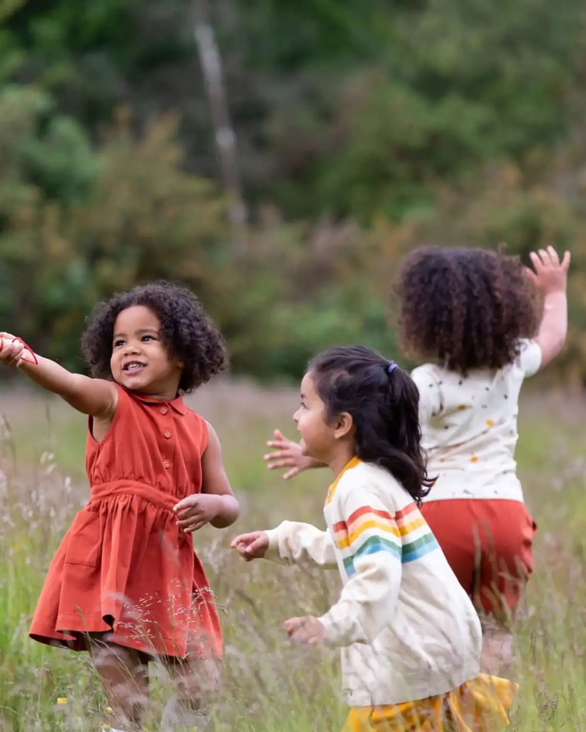 Child wearing Little Green Radicals organic cotton playwear with colorful prints.