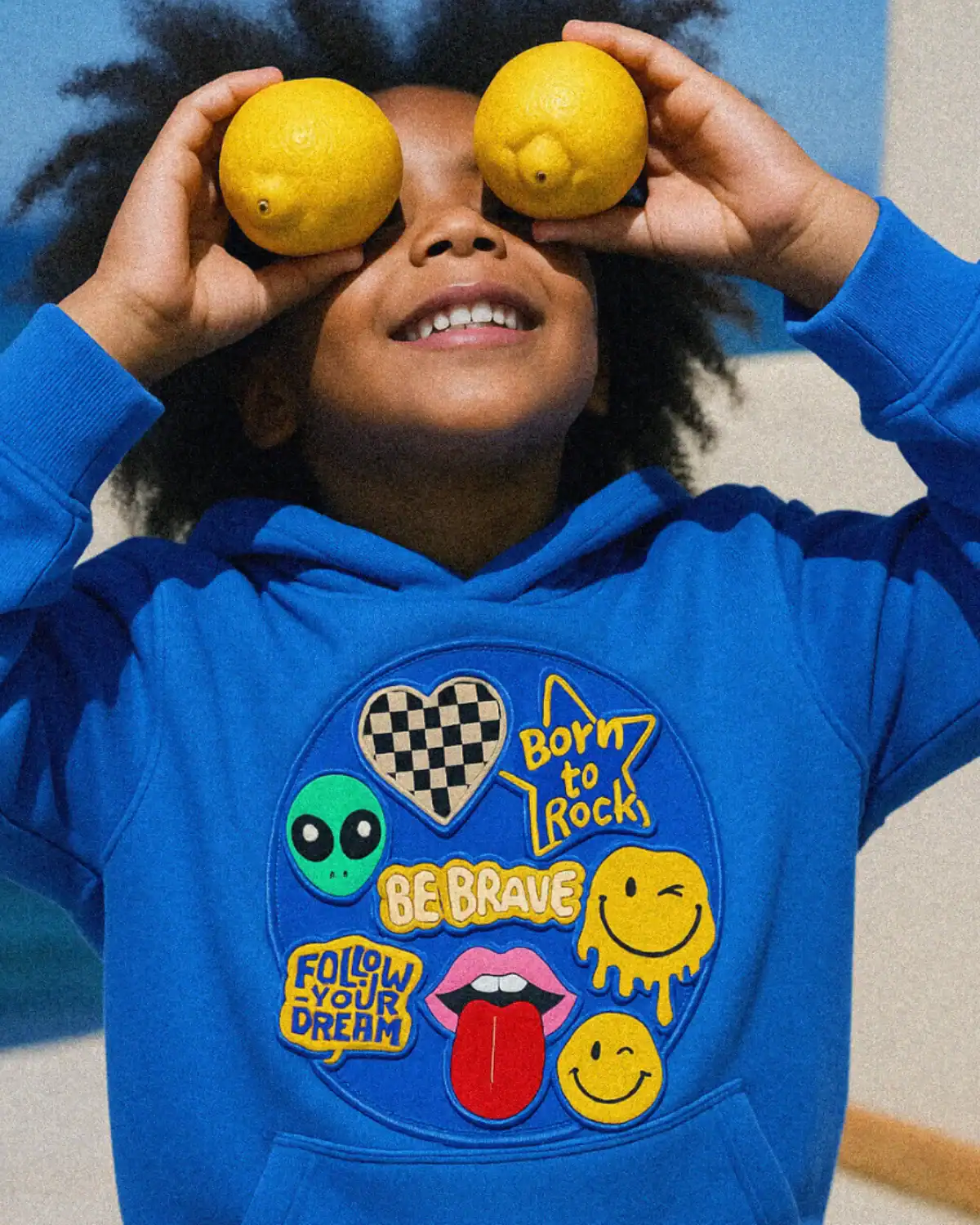 Child wearing GOTS-certified organic cotton hoodie from Hahaha organic kids clothing brand.