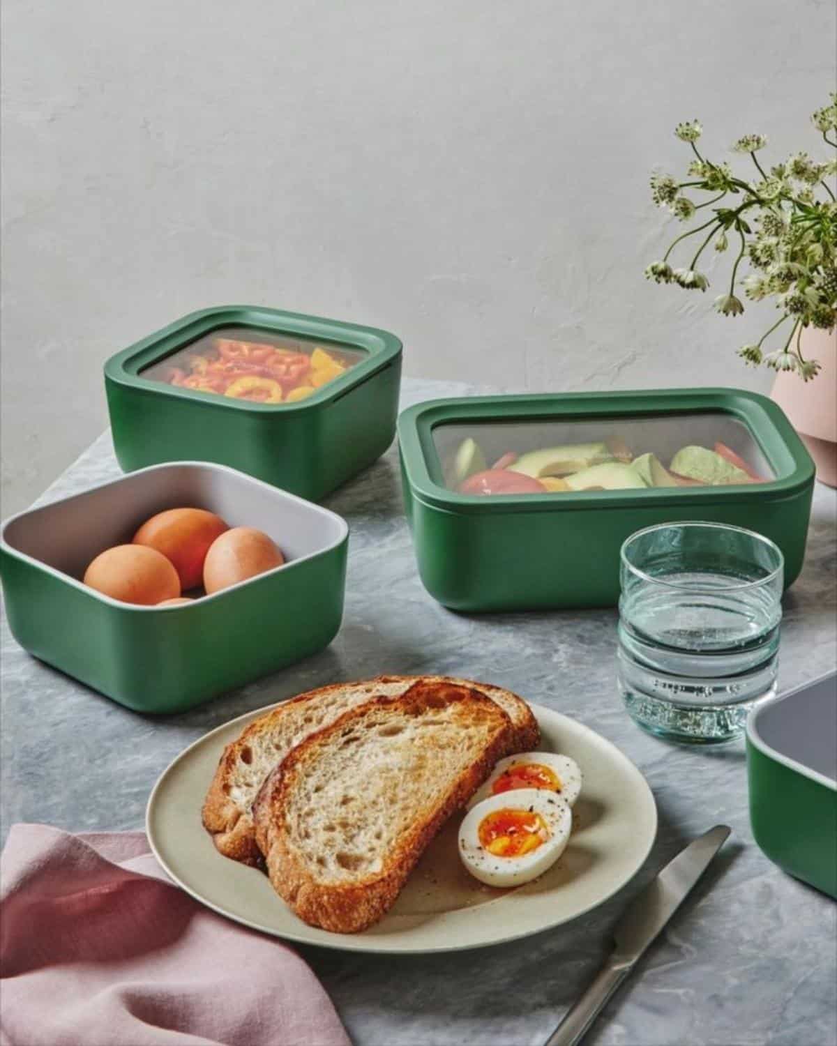 Non-toxic food storage containers made from glass, stainless steel, and silicone on the kitchen counter.