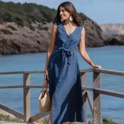 MagicLinen Acadia sleeveless linen midi dress in deep navy blue with button-front detail, tie waist, and breathable linen fabric.