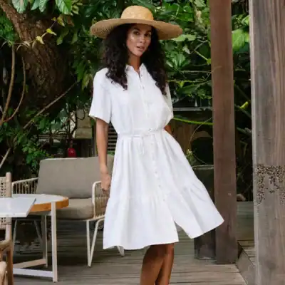 MagicLinen Agra white linen maxi dress featuring a wrap-style bodice, flutter sleeves, side slit, and relaxed summer silhouette.