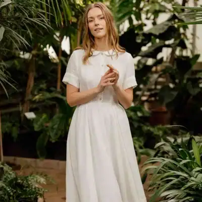 Son de Flor white linen midi dress featuring a Peter Pan collar, short sleeves, button-front detail, and a timeless vintage-inspired silhouette.