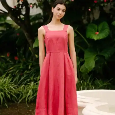 Son de Flor pinafore linen midi dress in wild rose pink featuring a sleeveless design, fitted bodice, and full flowing skirt.