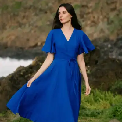 Son de Flor wrap linen dress in royal blue featuring butterfly sleeves, a flattering wrap silhouette, and a flowing midi-length skirt.