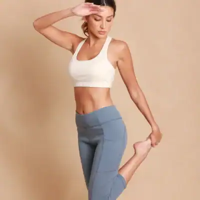 Woman stretching in Cottonique Cropped Leggings made from 100% GOTS-certified organic cotton without spandex.