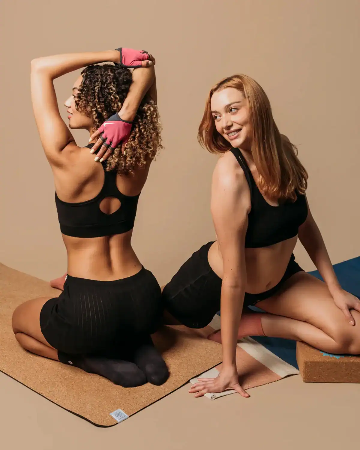 Two women stretching in Q for Quinn organic cotton activewear designed to reduce reliance on polyester and nylon.