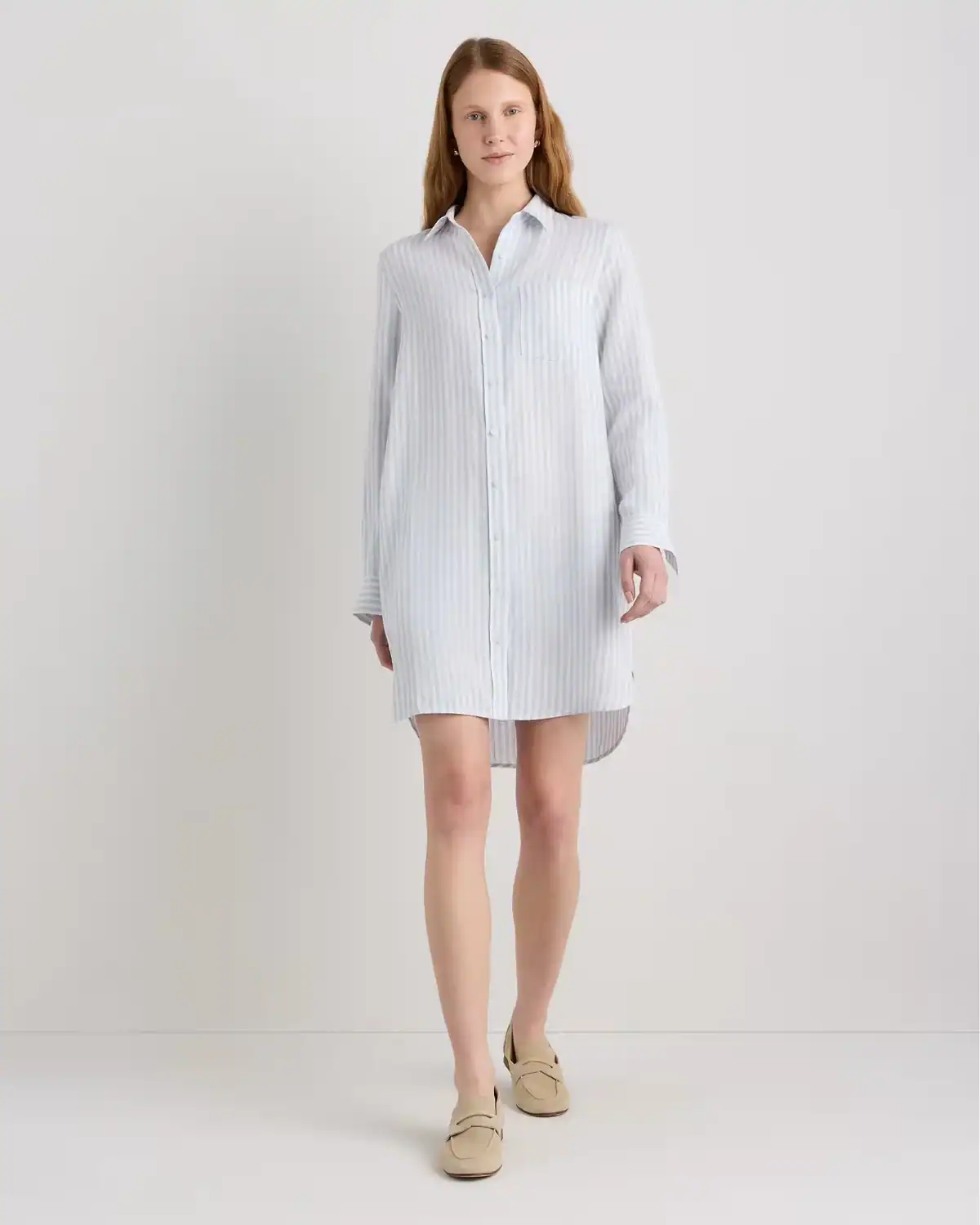 Woman wearing the Quince 100% European Linen Shirt Dress with a relaxed button-front silhouette, chest pocket, and waist pockets.