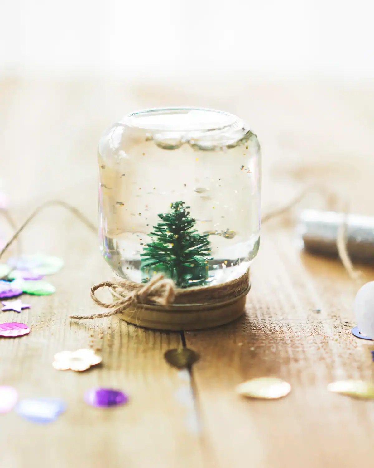 Homemade snow globe with a miniature figurine glued inside the lid.