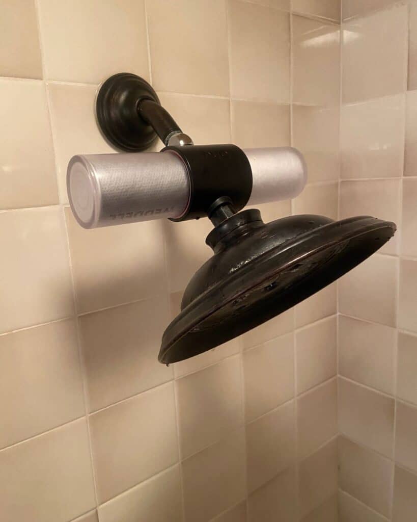 Weddell Duo shower filter installed behind a showerhead, with NSF-certified chlorine reduction and verified PFAS filtration.