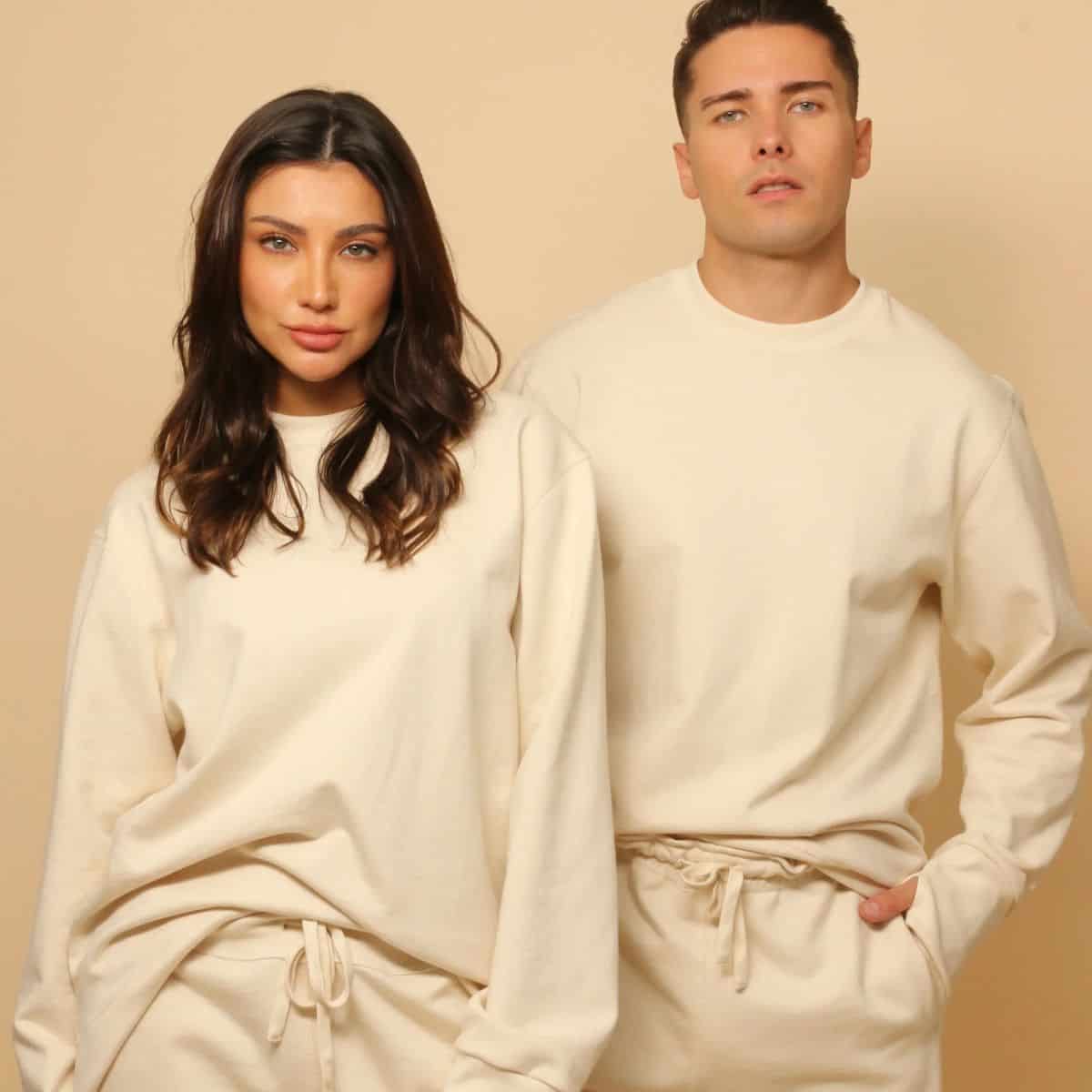 Woman and man wearing cream Cottonique hypoallergenic organic cotton sweatshirts featured in my guide to safer natural-fiber sweaters and knitwear.