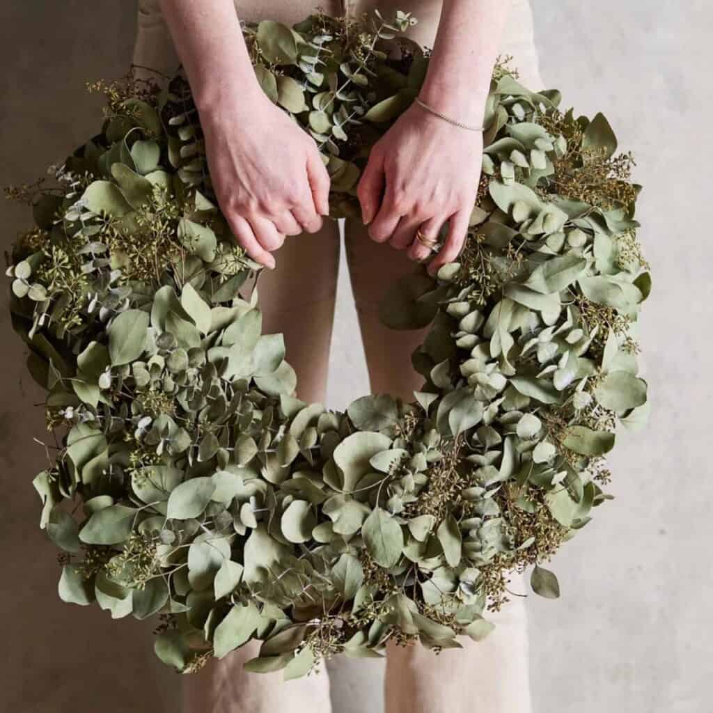Handmade eucalyptus wreath for non-toxic Christmas decor using natural greenery instead of artificial foliage.