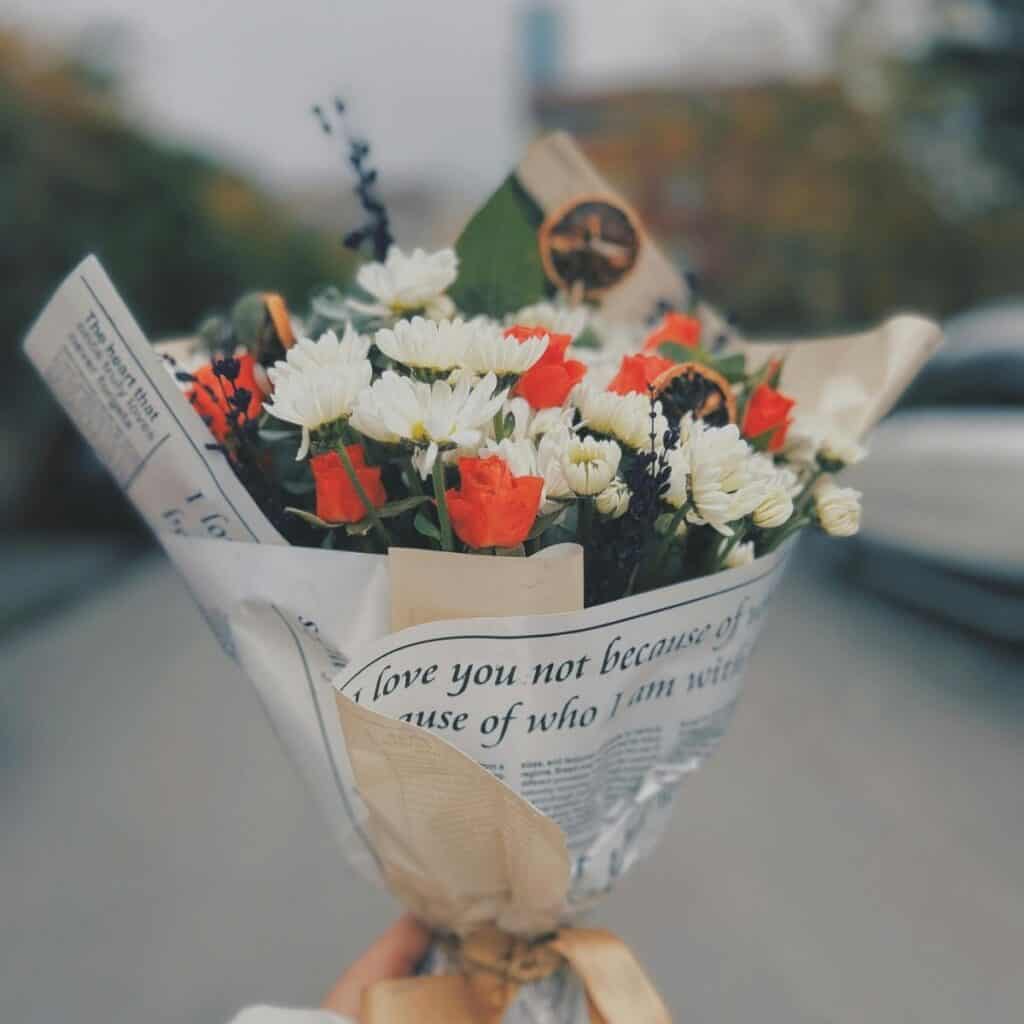 Bouquet wrapped in reused newspaper as an example of sustainable paper wrapping that can inspire eco-friendly Christmas gift wrapping.