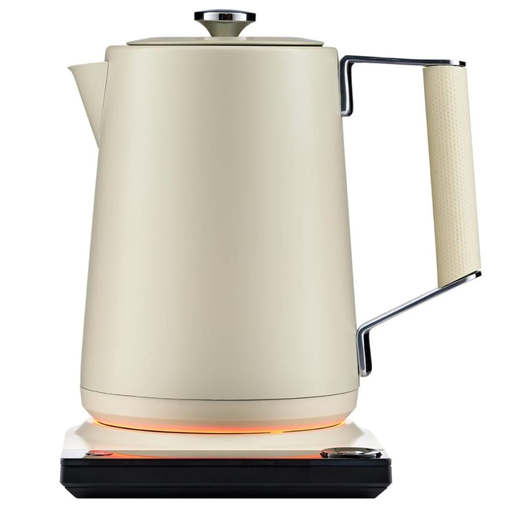 Cream-colored SAKI Luna Pro electric tea kettle with a textured handle and orange-lit ring above its control base