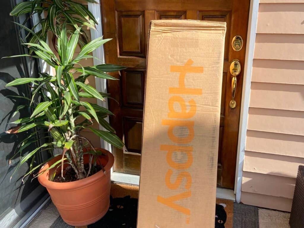 Happsy King mattress delivery box standing upright outside the front door before unboxing.
