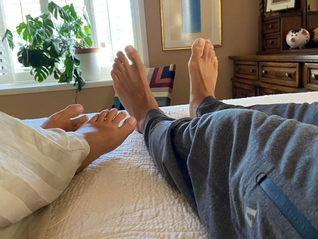 Two adults resting side by side on the Happsy Plush King mattress and topper during at-home sleep testing.